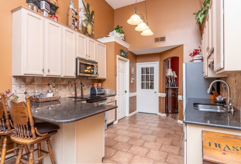 Kitchen with a breakfast bar featuring a dark granite countertop and integrated sink