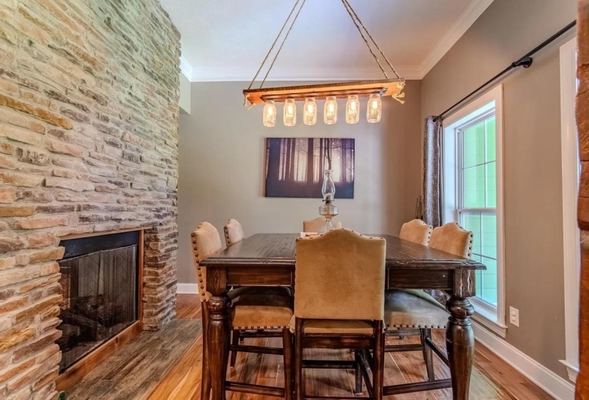 Stone-clad fireplace with black firebox and integrated wood-finish flooring surround