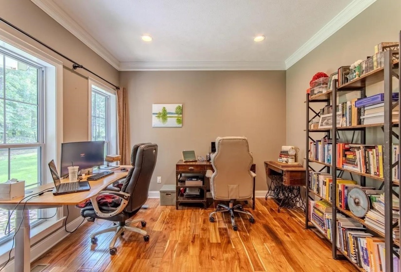 Spacious interior room featuring wood-finish flooring, crown molding, and recessed lighting