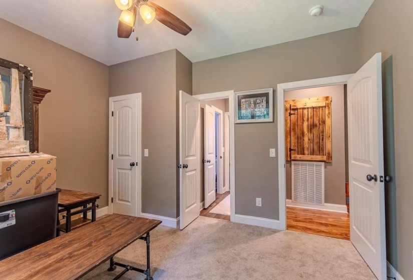 Neutral-toned room featuring a ceiling fan with integrated lighting, white baseboards, and neutral carpet flooring