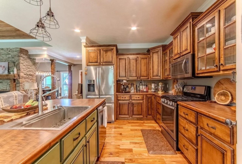 Spacious kitchen featuring extensive wood cabinetry, stainless steel appliances, and wood-finish flooring