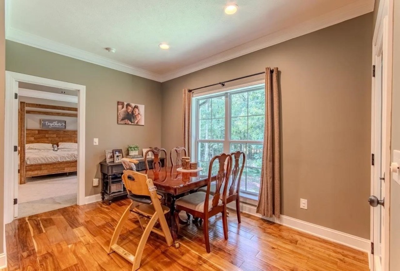 Room featuring wood-finish flooring, recessed lighting, and a large window with exterior tree scenery