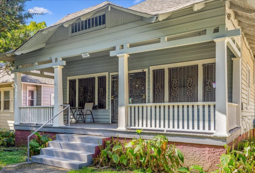 View of exterior entry with a porch and roof with shingles