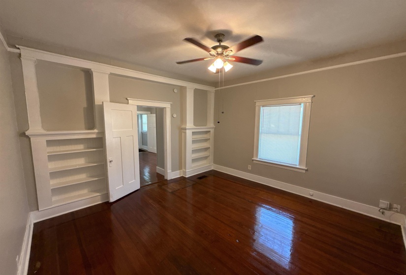 Unfurnished bedroom featuring dark wood-type flooring and ceiling fan