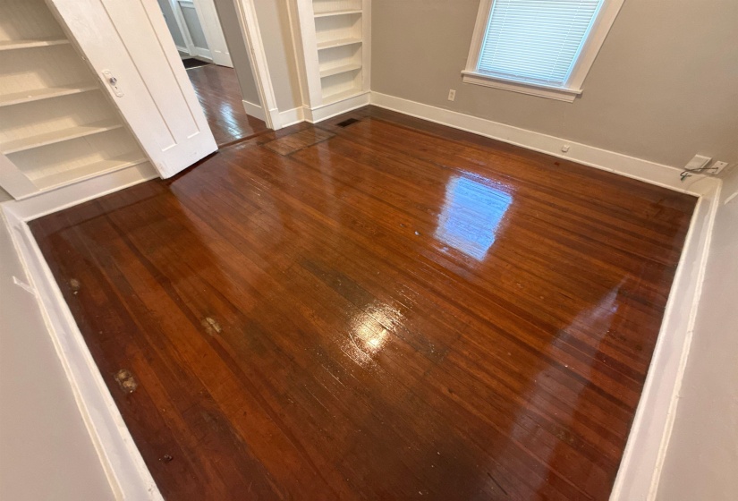 Unfurnished bedroom with dark wood-style flooring