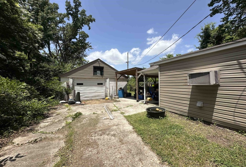 Detached garage with horizontal siding, overhead door, and an upper-level window