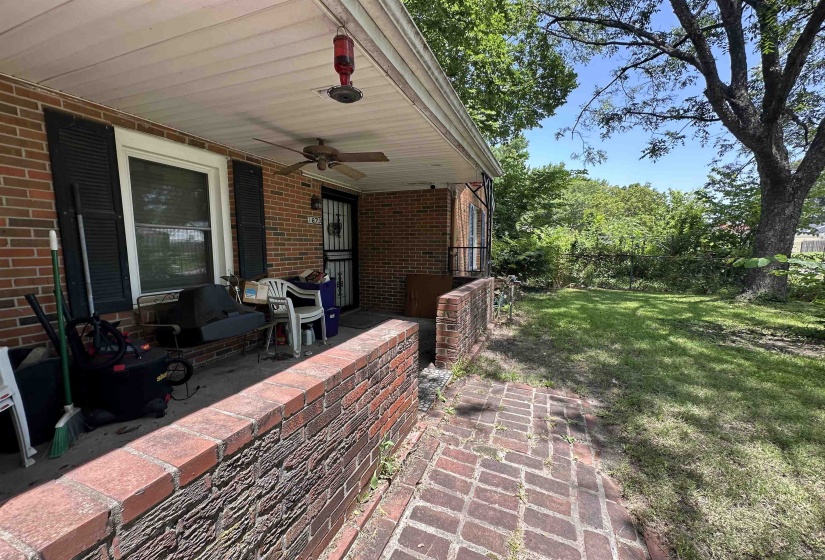 Front porch with brick facade, ceiling fan, and decorative screen door