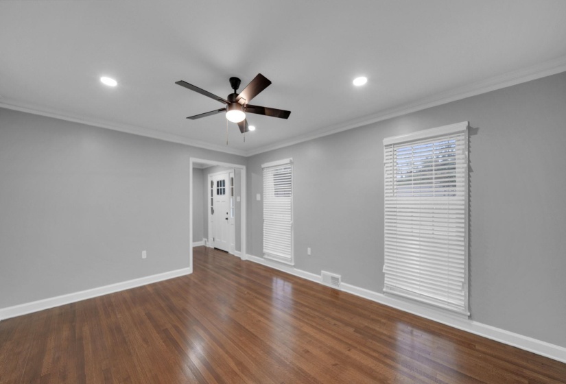 Empty room featuring ornamental molding, dark wood-type flooring, recessed lighting, and ceiling fan