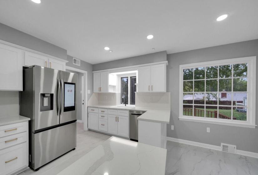 Kitchen with stainless steel appliances, white cabinetry, recessed lighting, and light marble finish flooring