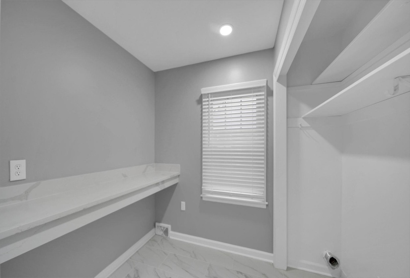Washroom with light marble finish floors and a desk