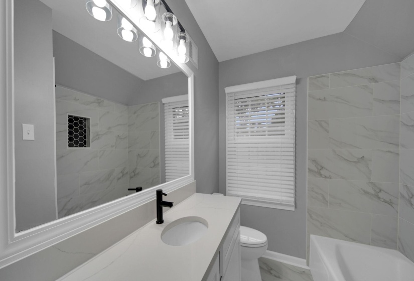 Full bathroom featuring light marble finish flooring and vanity