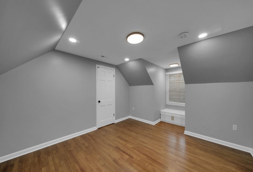 Additional living space with vaulted ceiling, light wood-type flooring, and recessed lighting