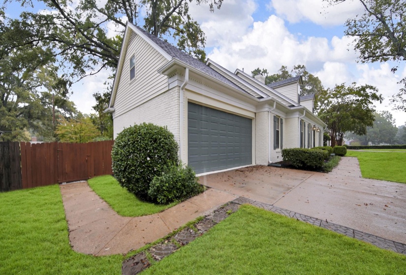 View of home's exterior featuring brick siding, concrete driveway, and an attached garage
