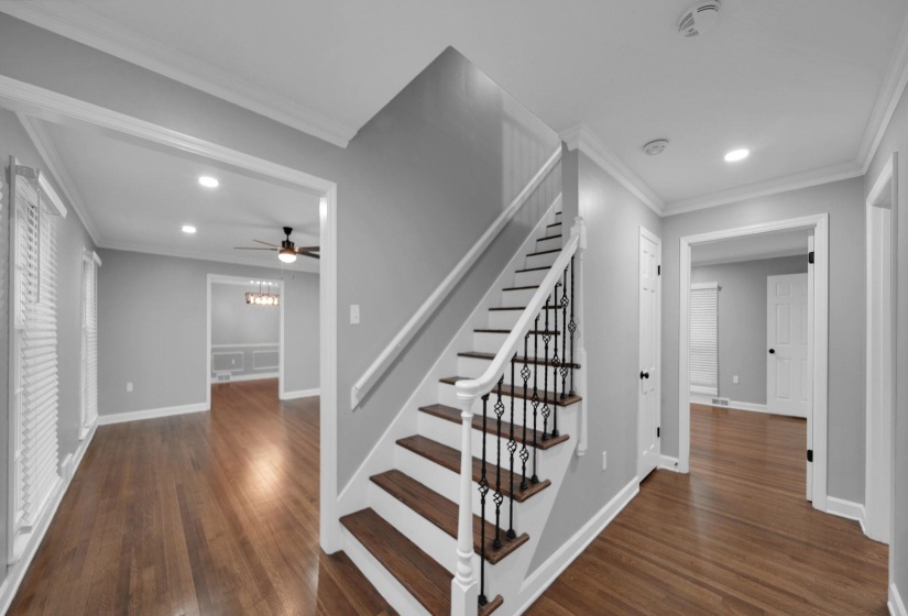 Stairway featuring ornamental molding, wood finished floors, recessed lighting, and a chandelier