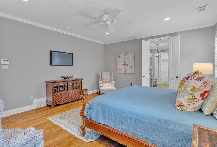 Spacious room featuring wood-finish flooring, crown molding, and recessed lighting