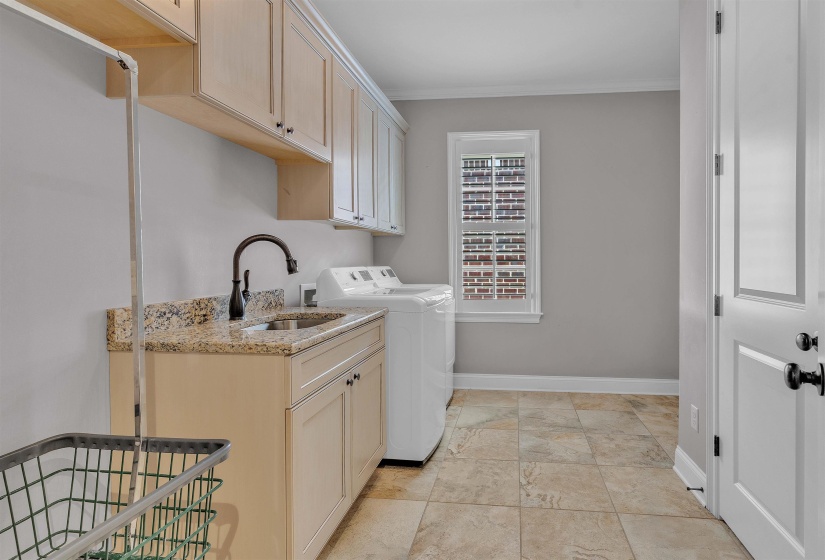 Laundry room with light cabinetry, granite-finish countertop, and a utility sink with a gooseneck faucet