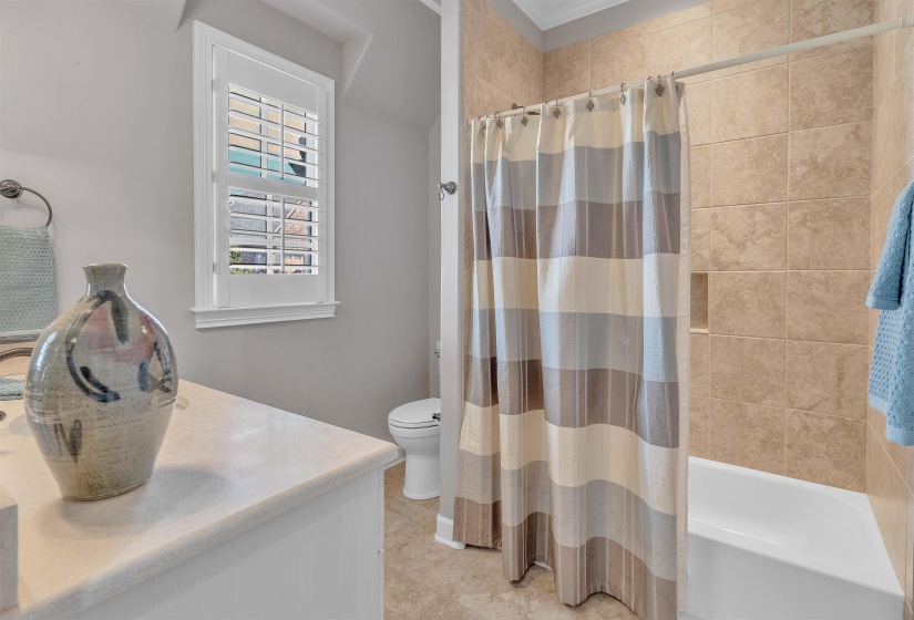 Bathroom featuring a tiled shower and tub combination, a toilet, and a vanity with a countertop