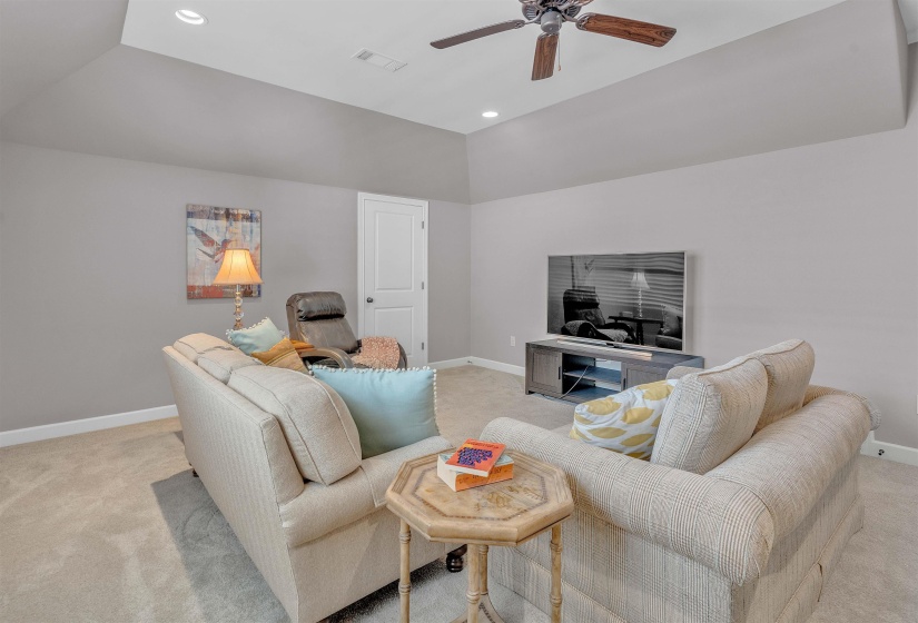 Vaulted ceiling room featuring recessed lighting, a ceiling fan, light-toned carpeting, white baseboards, and a white interior door