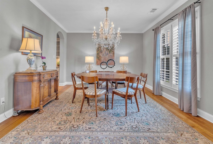 Formal dining space featuring hardwood flooring and a crystal chandelier