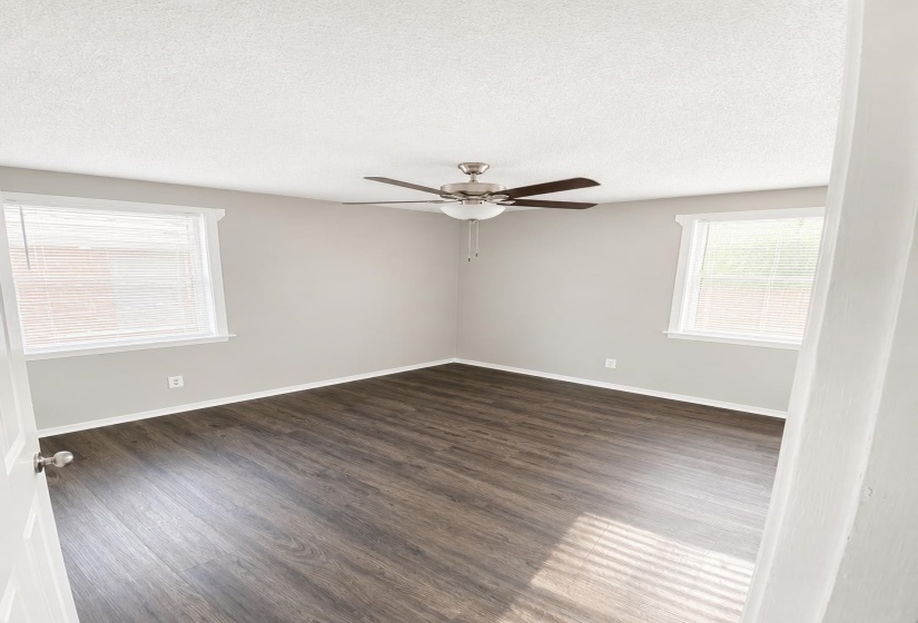 Room featuring wood-finish flooring, light grey walls, and white trim