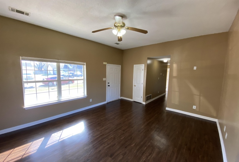 Spacious living area featuring wood-finish flooring and neutral wall tones
