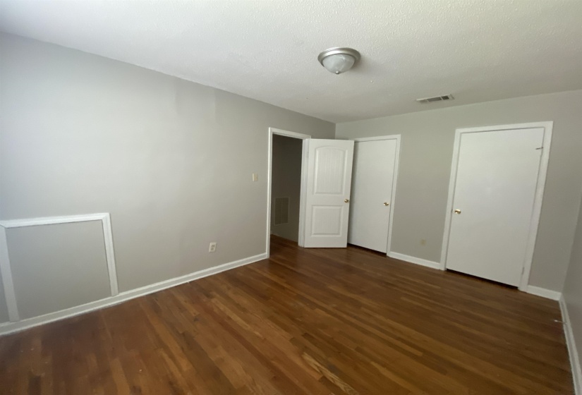 Wood-finish flooring with light gray walls and white trim