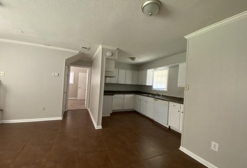 Kitchen featuring white cabinetry, dark countertops, and a white dishwasher