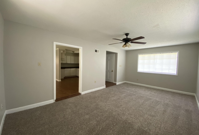 Living area featuring neutral-tone carpeting, light grey wall paint, and white trim