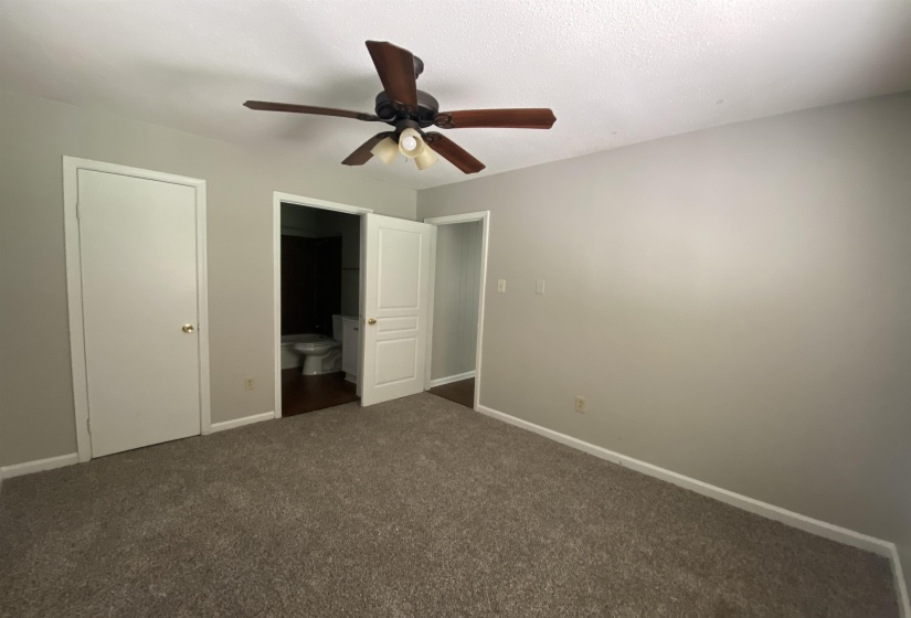 Carpeted interior space featuring a ceiling fan with integrated lighting, light gray painted walls, and white trim