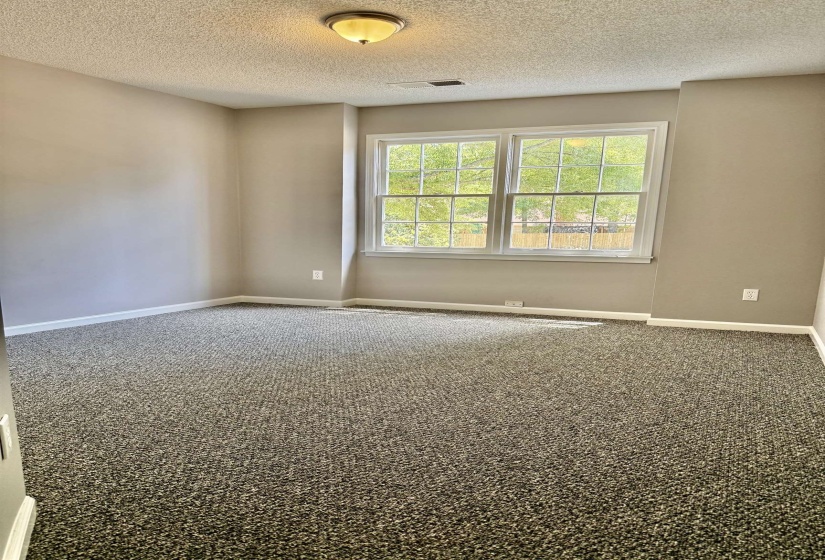 Interior room featuring neutral wall paint and textured carpeting