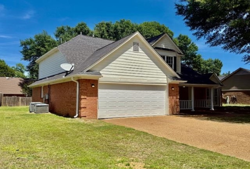 Brick and siding exterior featuring a prominent two-car garage