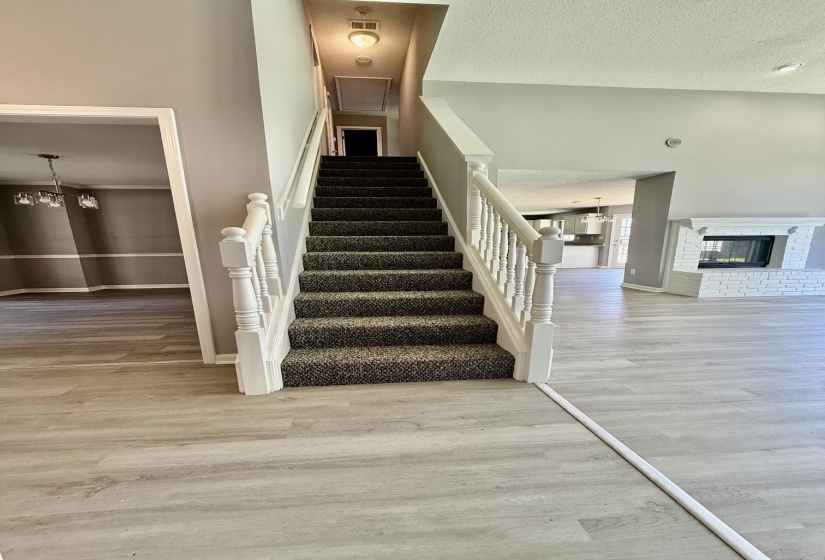 Central staircase with carpeted treads and white wood balusters