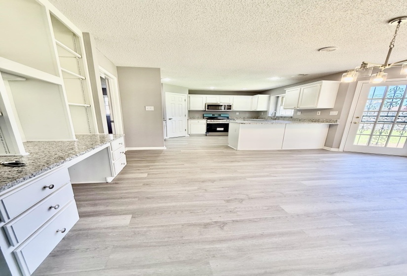 Light wood-finish flooring extending through an open-concept living area