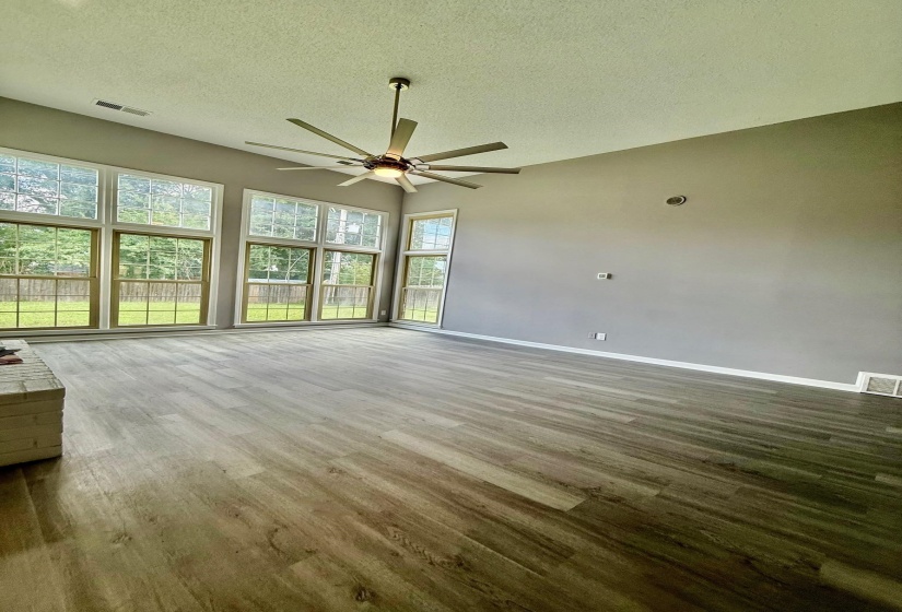 Spacious interior featuring wood-finish flooring, vaulted ceilings, and a modern ceiling fan