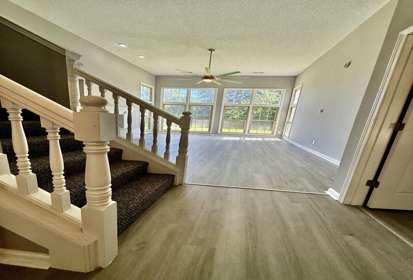 Living area featuring wood-finish flooring, a contemporary ceiling fan, and recessed lighting