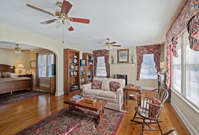 Hardwood flooring throughout the main living area and an arched doorway leading to an adjoining room