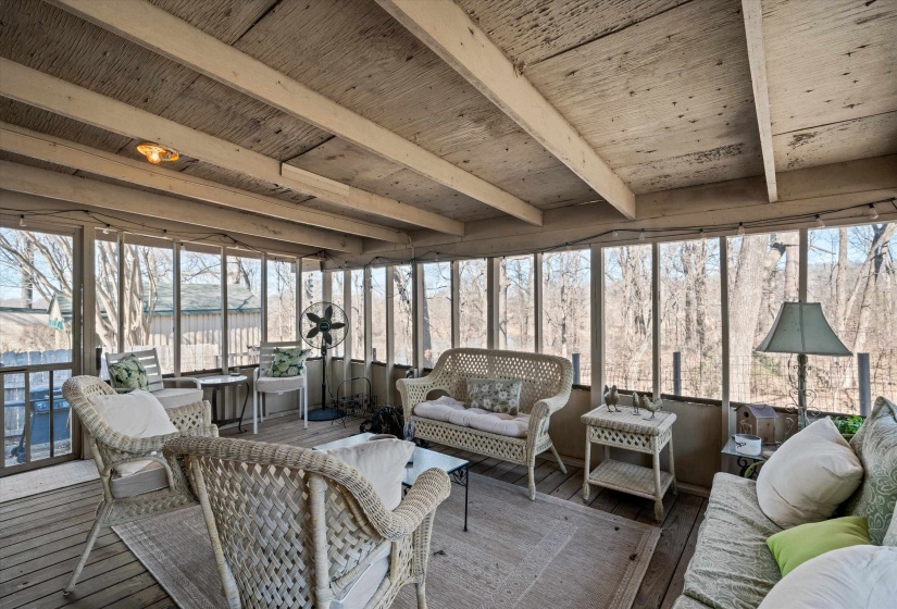 Screened-in porch featuring wood-finish flooring, exposed beam ceiling, and expansive perimeter screening
