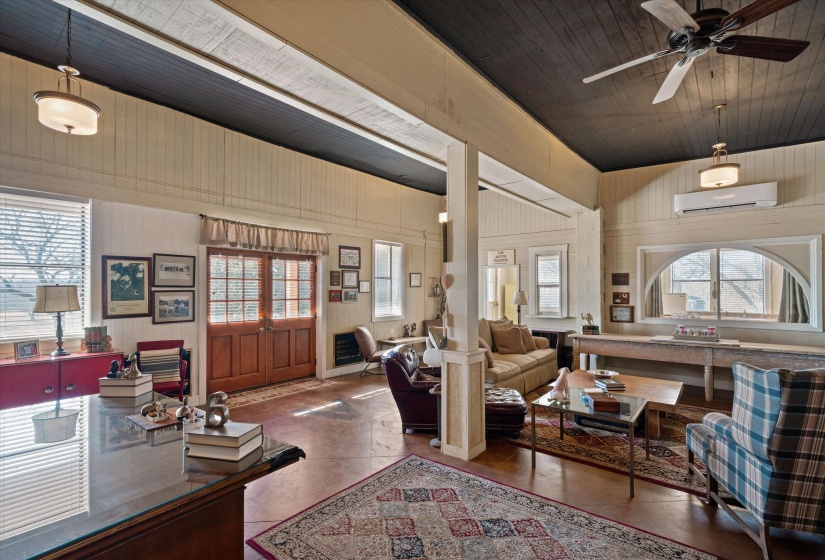 Spacious interior featuring a dark wood-finish vaulted ceiling, exposed wood beams, and light-toned vertical paneling