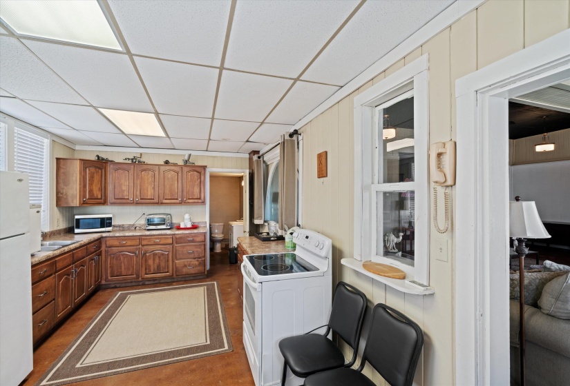 Kitchen featuring extensive wood cabinetry, L-shaped countertops, and a full-size electric range