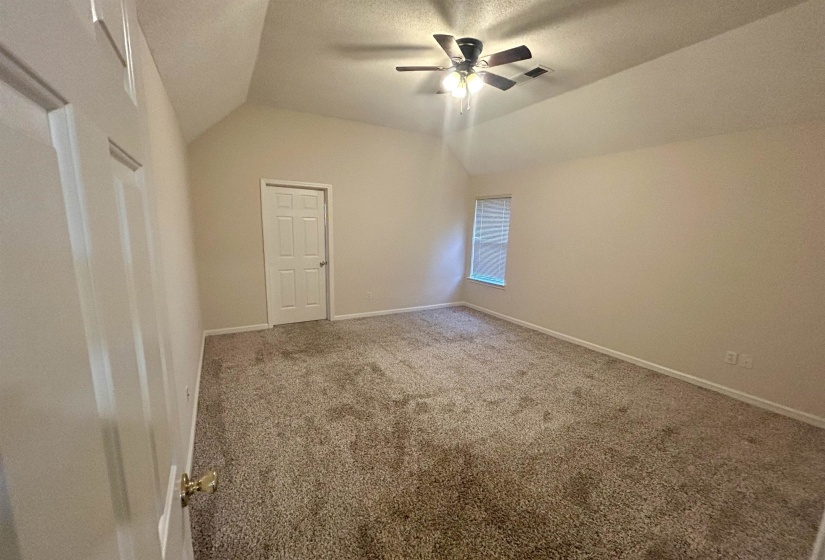 Carpeted room featuring a vaulted ceiling and a ceiling fan