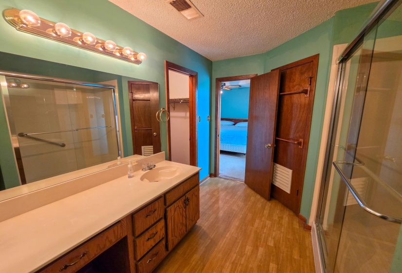 Vanity area featuring a single basin, ample countertop space, and wood-finish cabinetry
