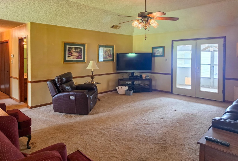 Spacious room featuring broadloom carpet and two-tone wall treatment with wainscoting