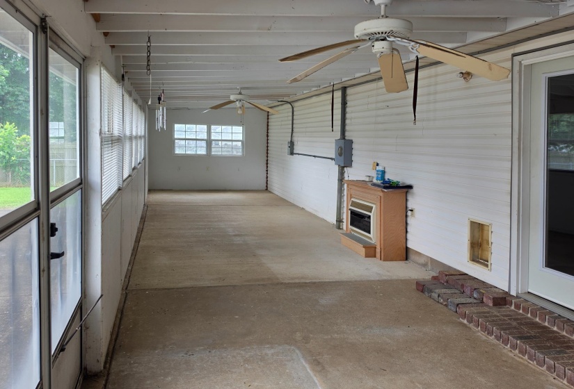 Enclosed patio space featuring a concrete floor and a full wall of vertical windows
