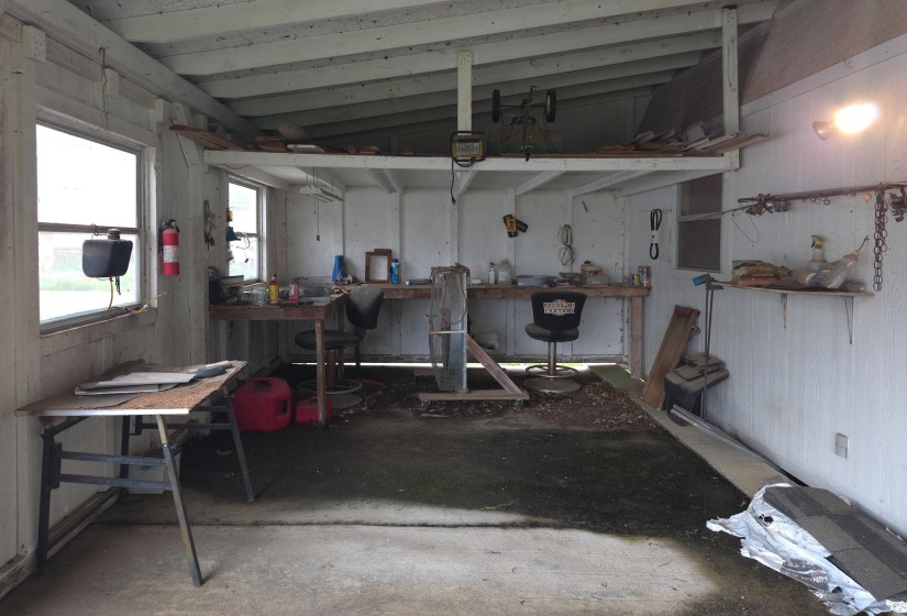 Utility space featuring a concrete floor, exposed ceiling beams, and multiple windows
