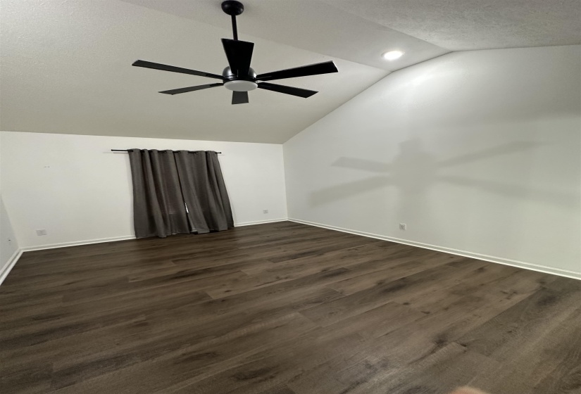 Vaulted ceiling with a black ceiling fan and recessed lighting