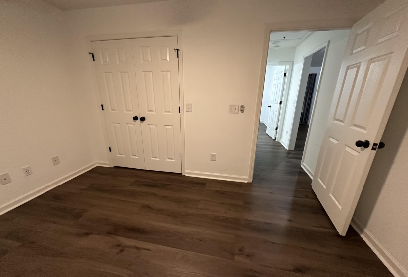 Interior room featuring wood-finish flooring and white baseboards