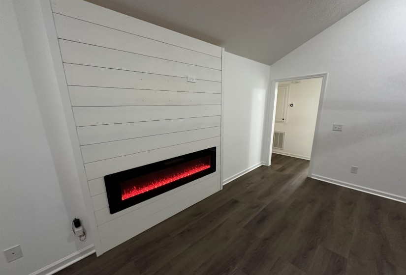 Feature wall with horizontal white shiplap paneling and an integrated linear electric fireplace