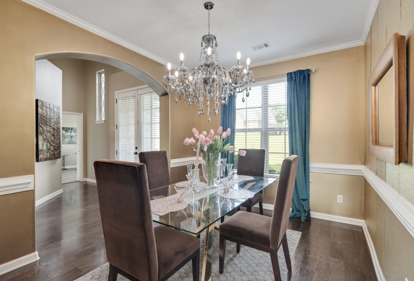 Formal dining area featuring a crystal chandelier and wood-finish flooring