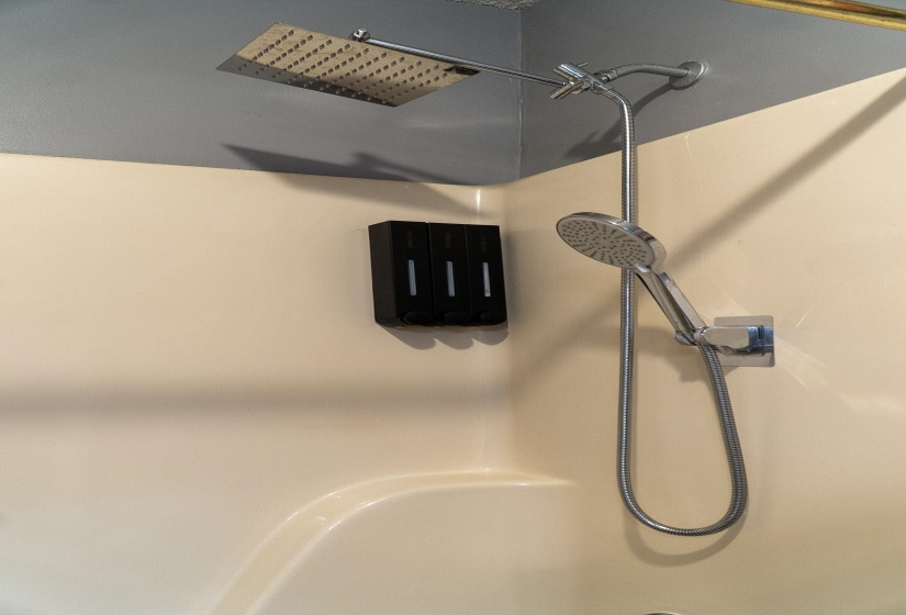 Chrome finish shower fixture with a rainfall showerhead and an additional handheld sprayer