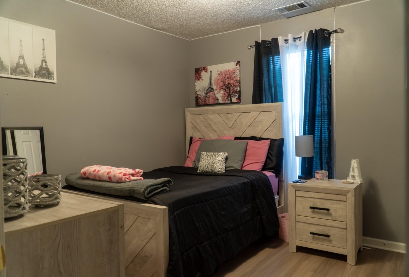 Bedroom featuring wood-finish flooring and a light gray wall color